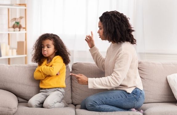 mom scolding daughter with her back turned