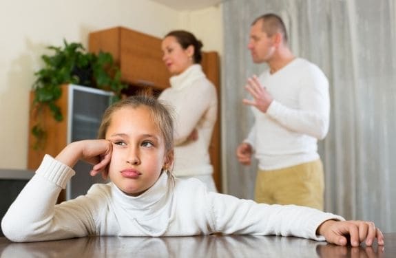 daughter looking grumpy with kids in the background upset