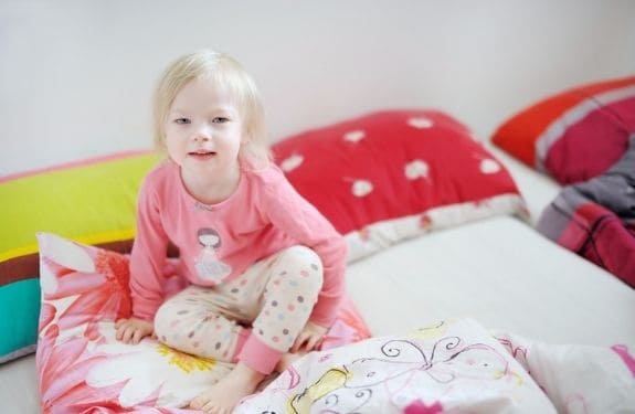 toddler in pajamas on bed