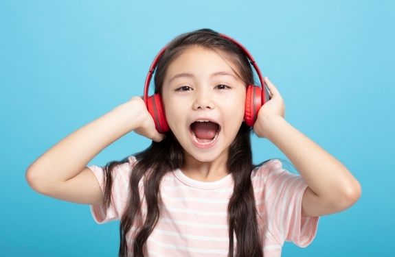Girl with headphones on and covering hear ears not listening