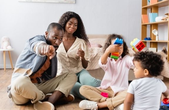 mom and dad sitting on floor with two kids