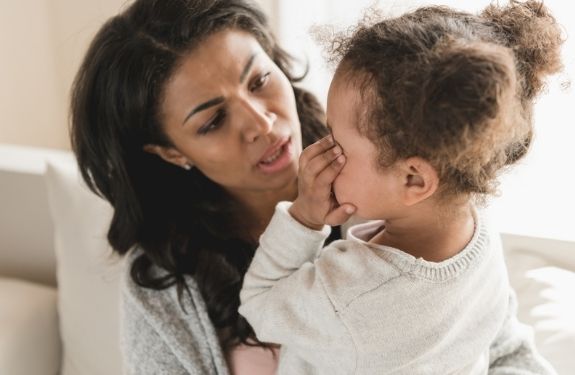 Mom comforting crying toddler daughter