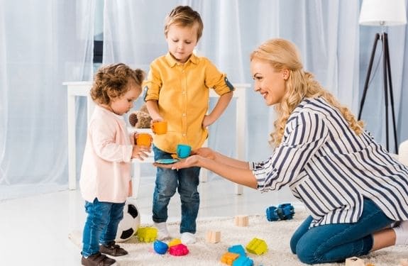 mom and two kids. Passing a toy between herself and the daughter
