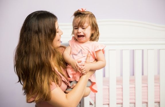 Mom comforting crying toddler girl