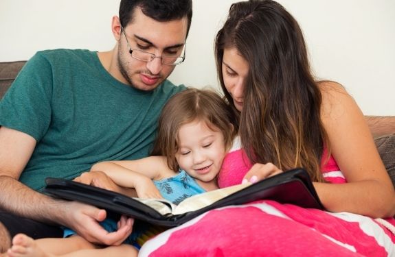 mom, dad and child reading bible