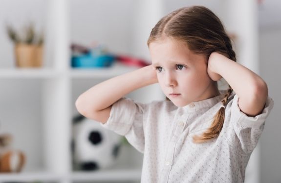 small girl covering her ears not listening