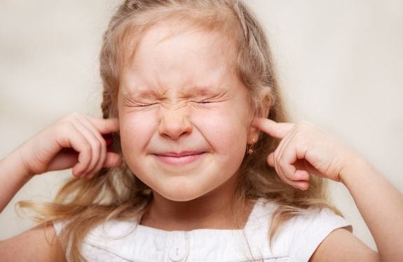 girl plugging her ears with fingers not listening