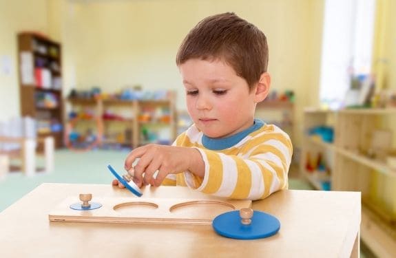 Toddler playing with wooden montessori style toy