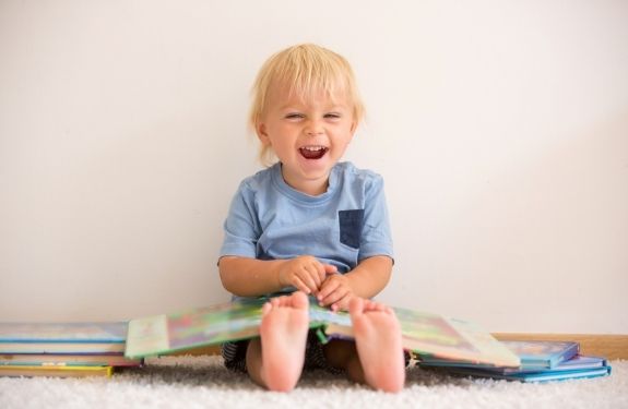 Toddler smiling with open book