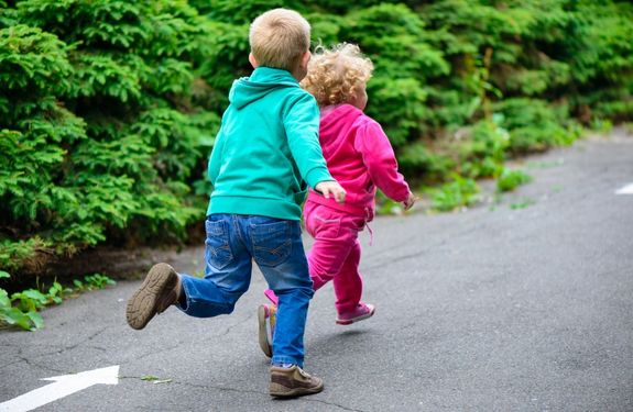 Stock image of two small children running away