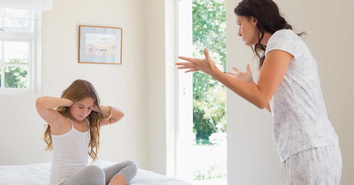 stock image of mother yelling at child who is covering her ears